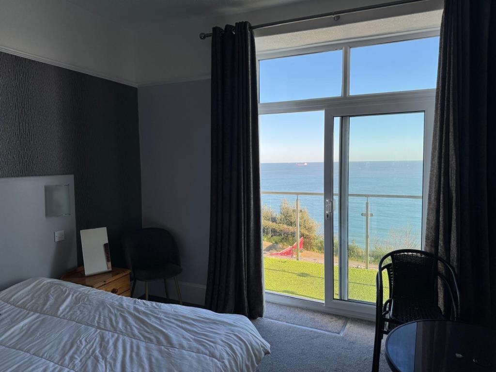 Lot: 89 - FREEHOLD CLIFF TOP HOTEL WITH TWENTY EN-SUITE GUEST ROOMS AND STUNNING VIEWS - A bedroom at the front of the Hotel